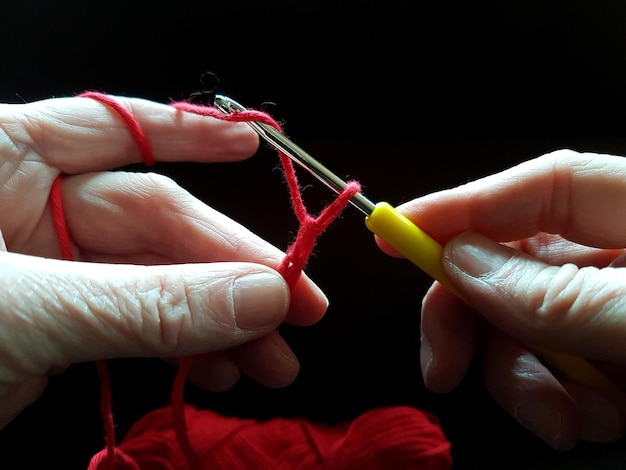 Ręce trzymają igłę i nici
